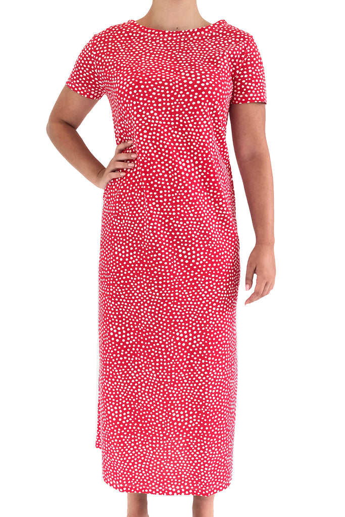 A woman wearing a boat neck collar See Design red polka dot knit dress full length.