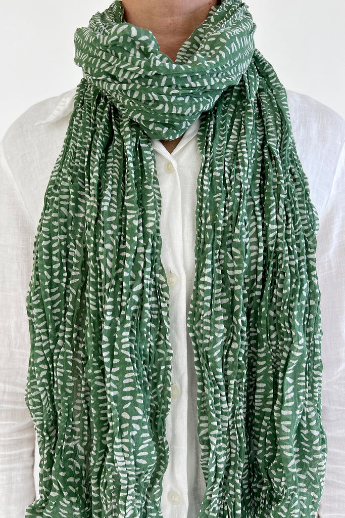 A woman accessorizing with a See Design cotton scarf.