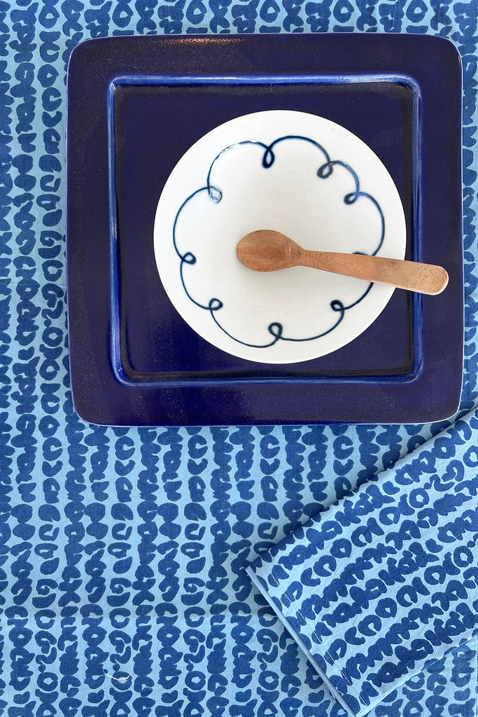 A vibrant blue Table Runner with a spoon on it by See Design.