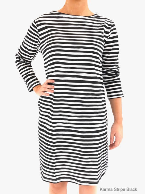 A woman wearing a versatile See Design black and white striped knit dress 3/4 sleeve.
