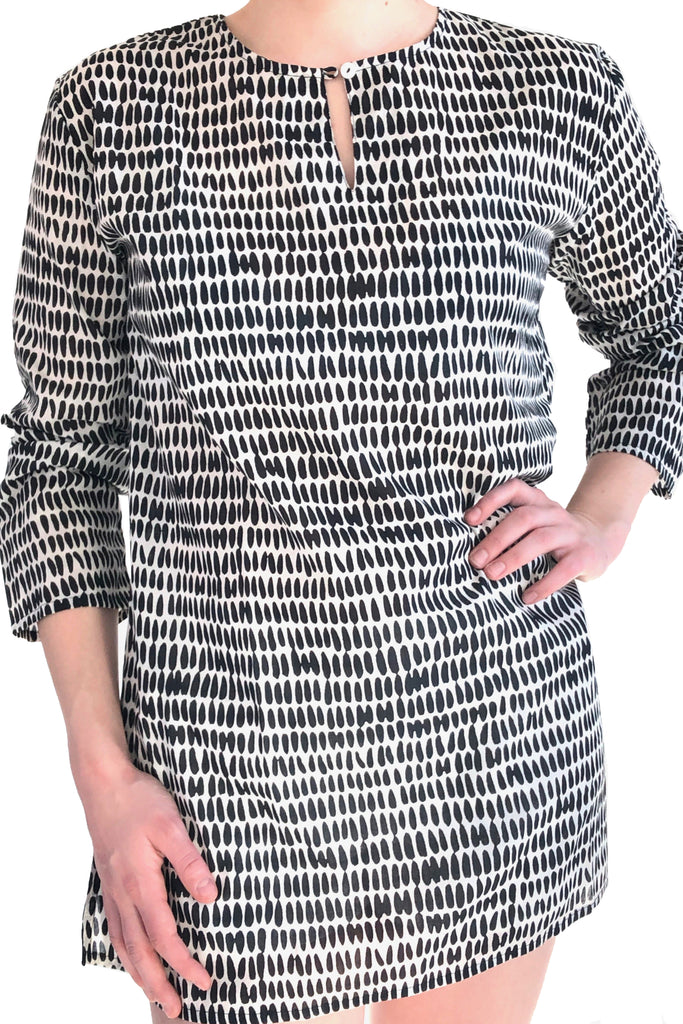 A versatile woman wearing a lightweight black and white printed tunic made of cotton voile by See Design.