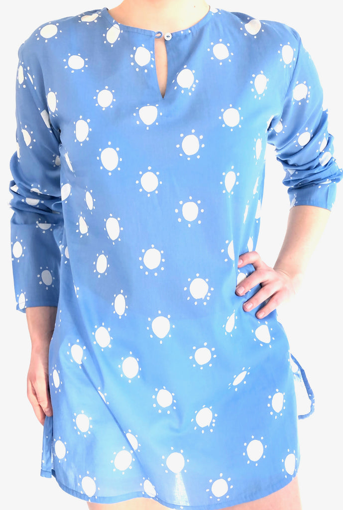 A woman wearing a lightweight blue See Design tunic with white stars on it.