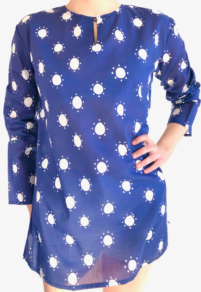 A woman wearing a lightweight blue See Design tunic with white stars on it.