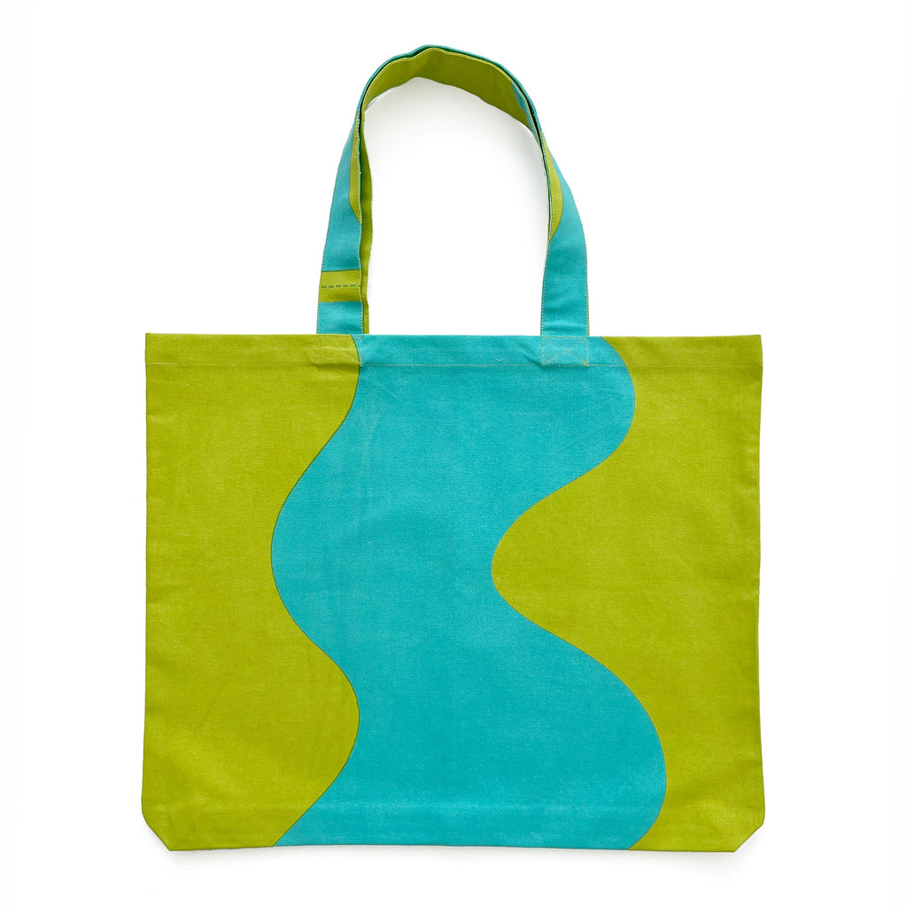 A lightweight, hand-painted cotton canvas Graphic Tote Bag with a wave design in green and blue from See Design.