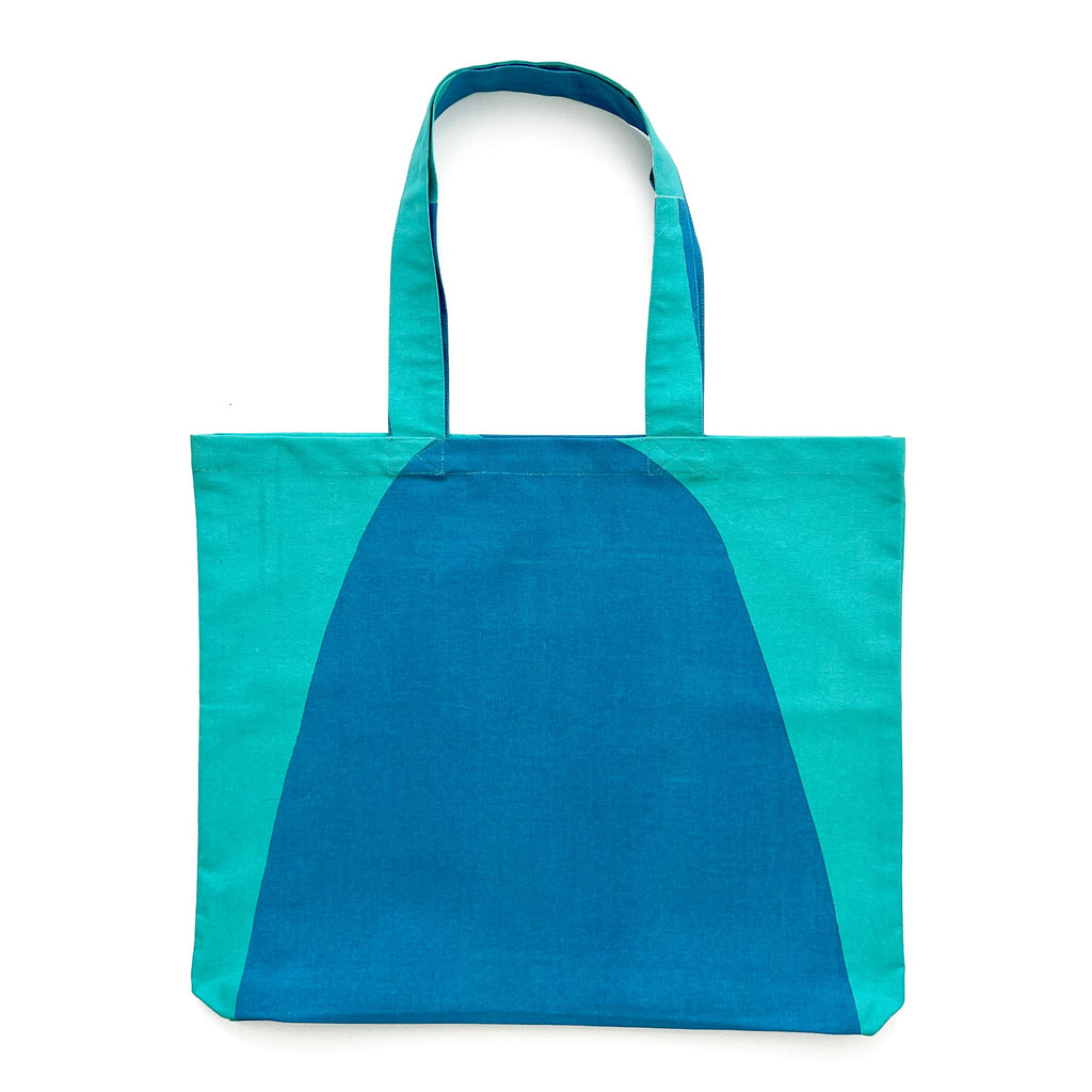 A lightweight Graphic Tote Bag by See Design featuring hand-painted artwork in shades of blue and teal.