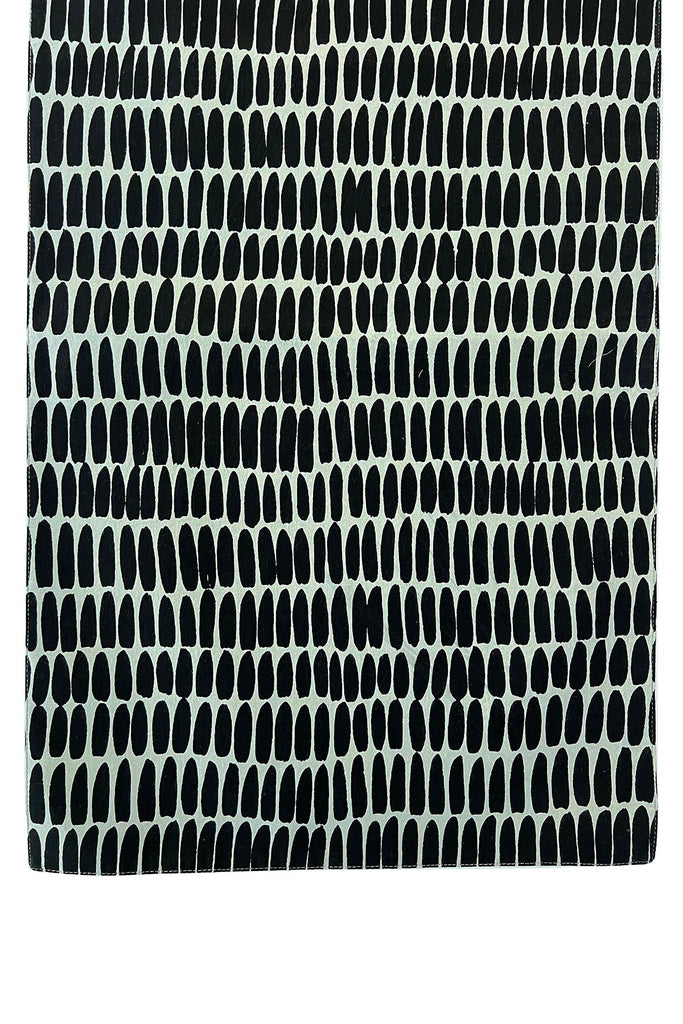 A black and white See Design table runner with a pattern.