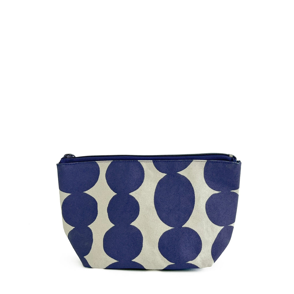 A compact cosmetic bag with polka dots for small travel essentials, called the "Travel Pouch Small" by See Design.