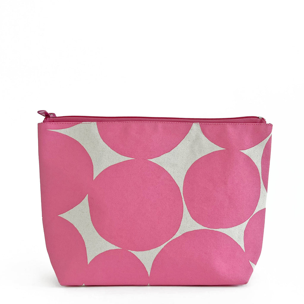 A pink and white cotton canvas Travel Pouch Large by See Design with polka dots and top zipper.