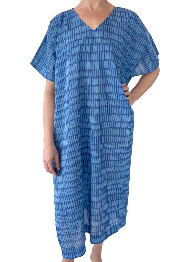 A woman wearing a blue See Design Caftan Long dress, perfect as a beach cover up or lounge piece.