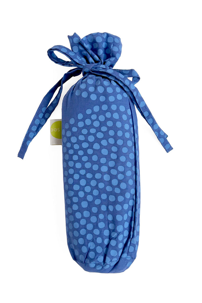 A lightweight blue polka dot Sarong bag with a fashionable ribbon tied around it by See Design.