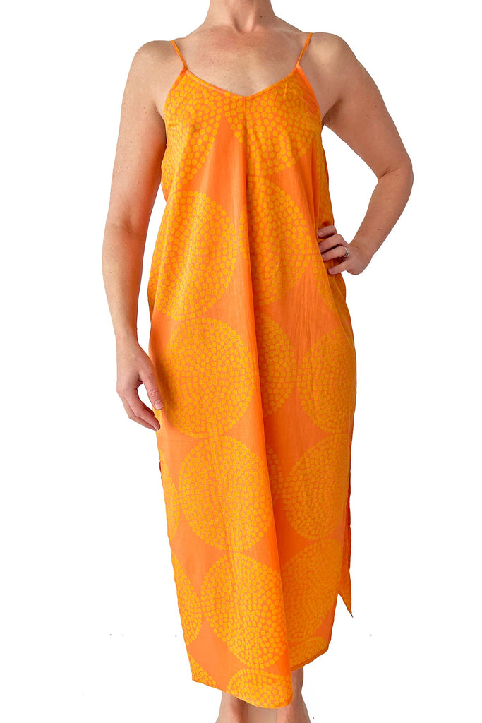 A woman in a See Design lightweight orange Slip Dress is posing for a photo.