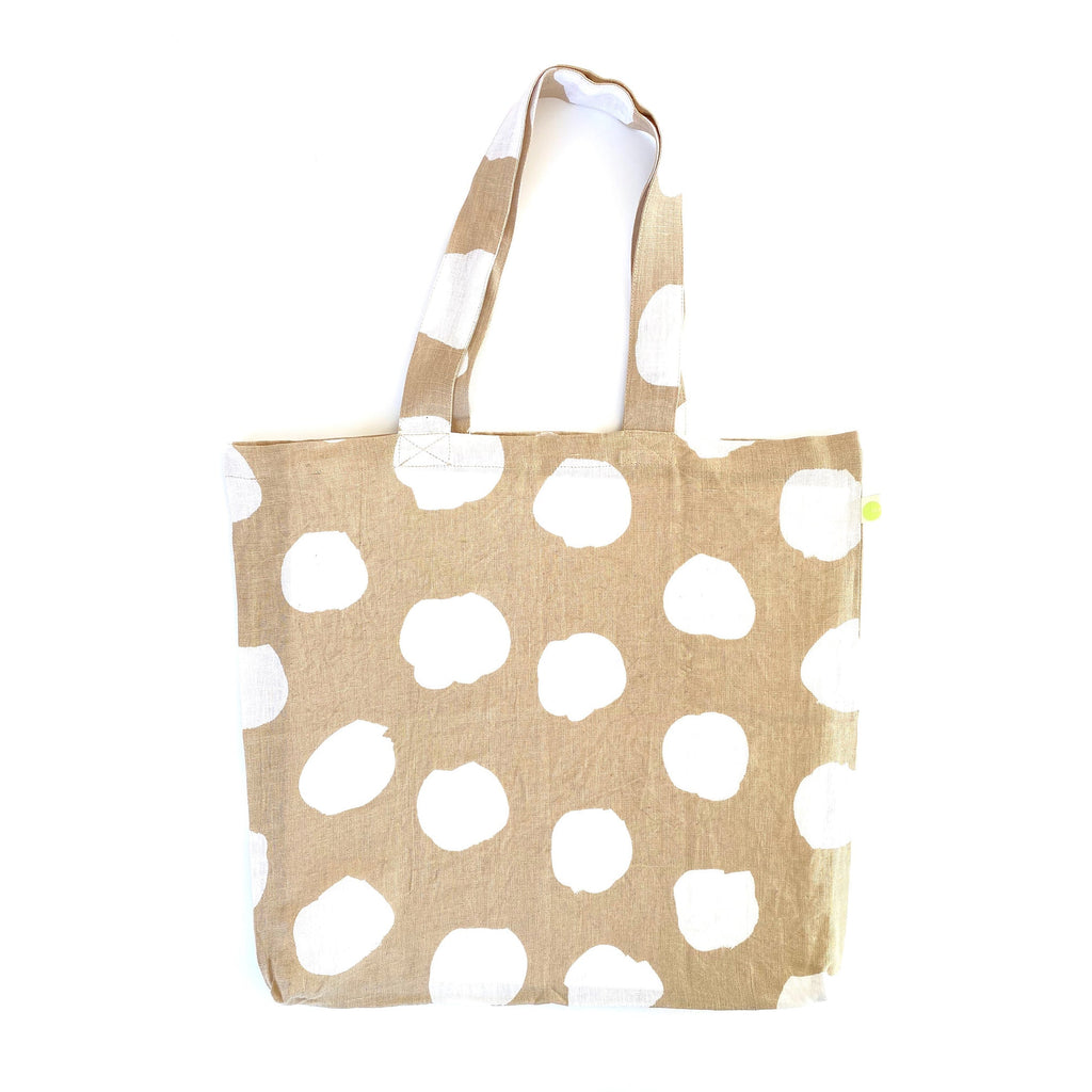 A sturdy beige and white polka dot Linen Everyday Tote Bag by See Design, perfect for shopping.