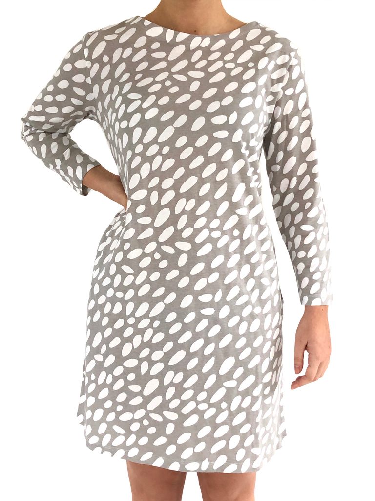 A versatile woman wearing a grey and white polka dot Knit Dress 3/4 Sleeve by See Design.