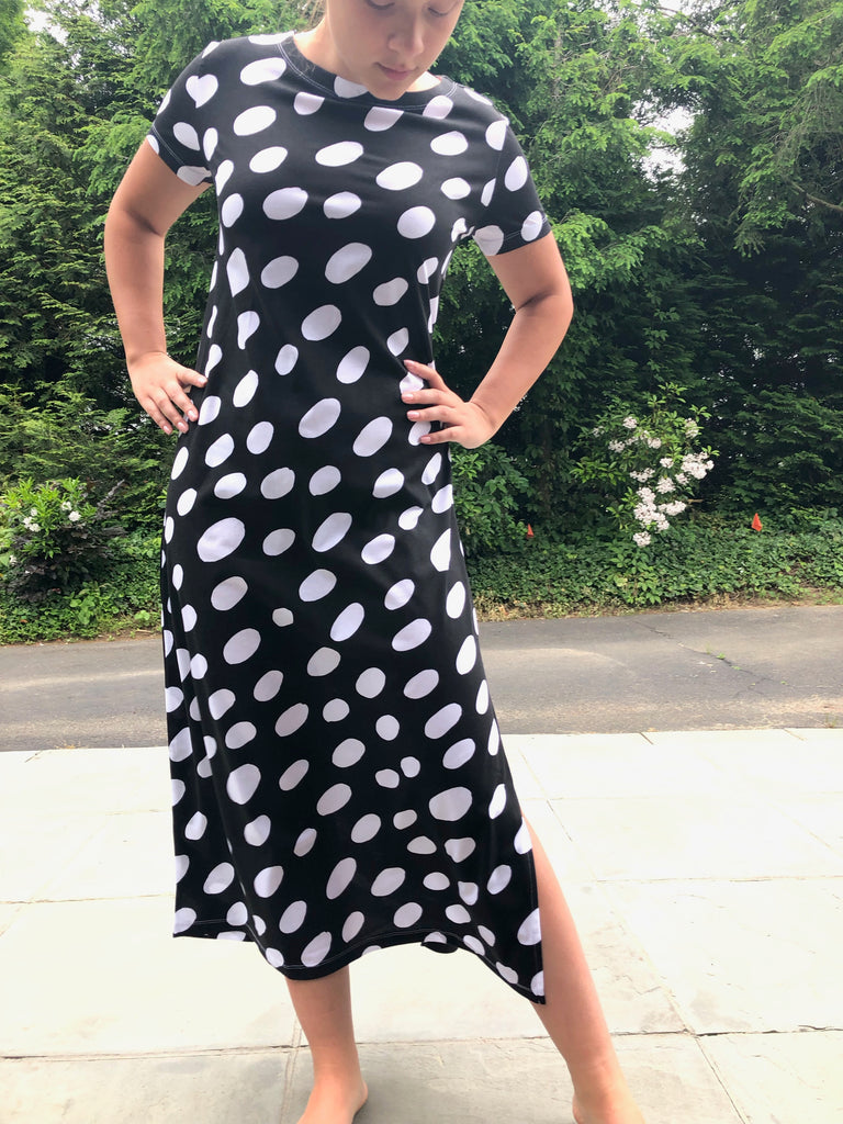 A woman in a comfortable black and white polka dot See Design Knit Dress Full Length.