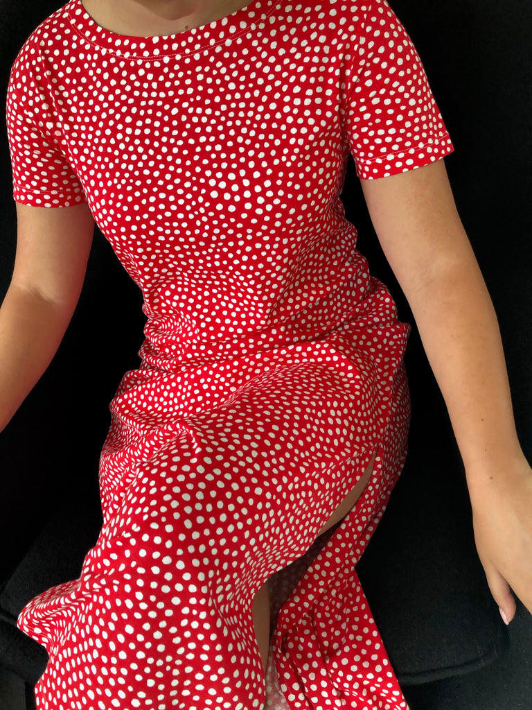 A woman in a comfortable red polka dot See Design Knit Dress Full Length.