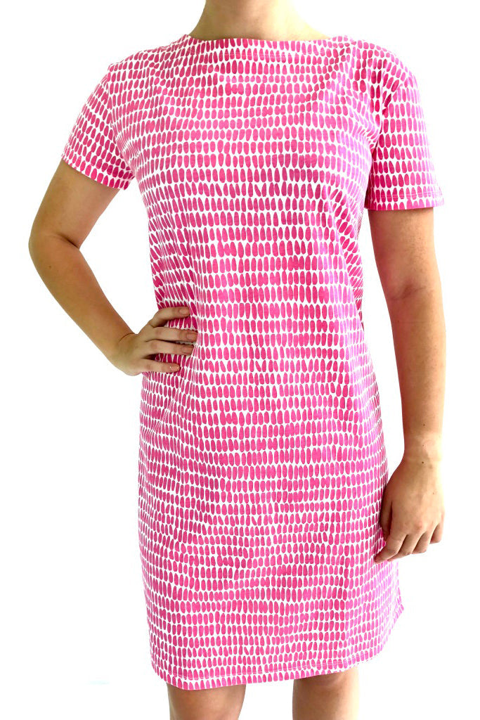 A versatile woman wearing a comfortable See Design pink knit dress with white polka dots.