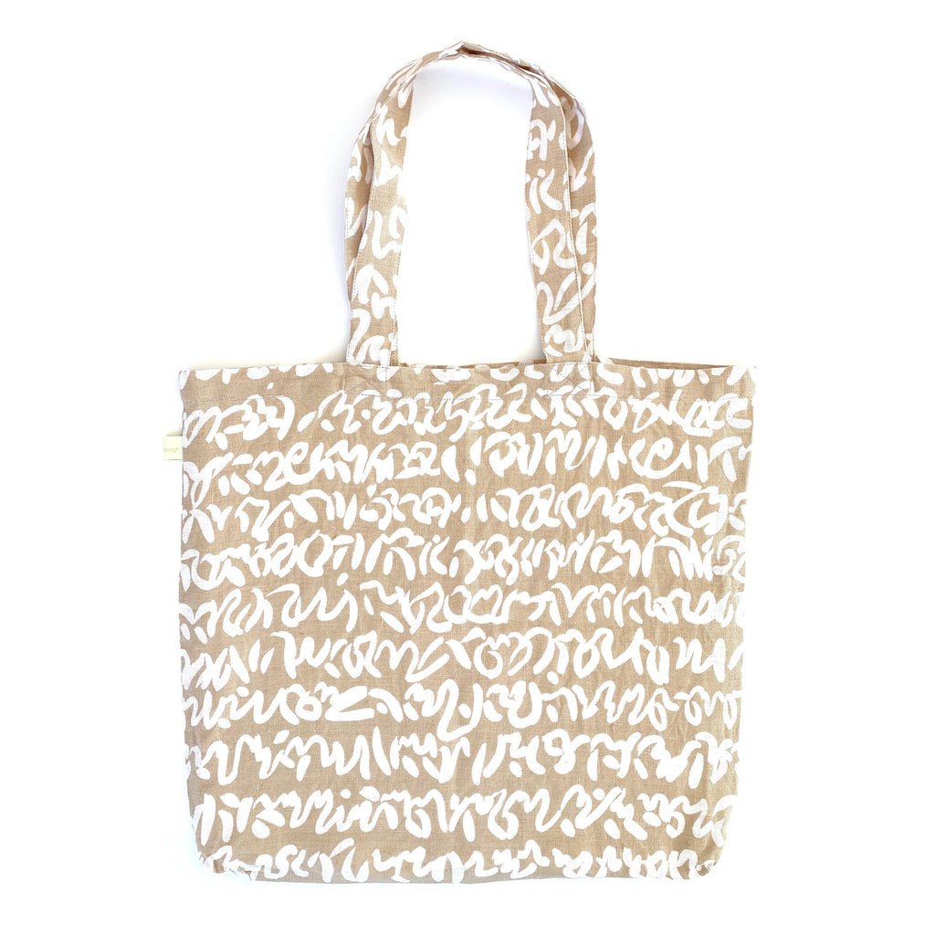 A sturdy Linen Everyday Tote Bag by See Design, perfect for shopping, featuring white writing.