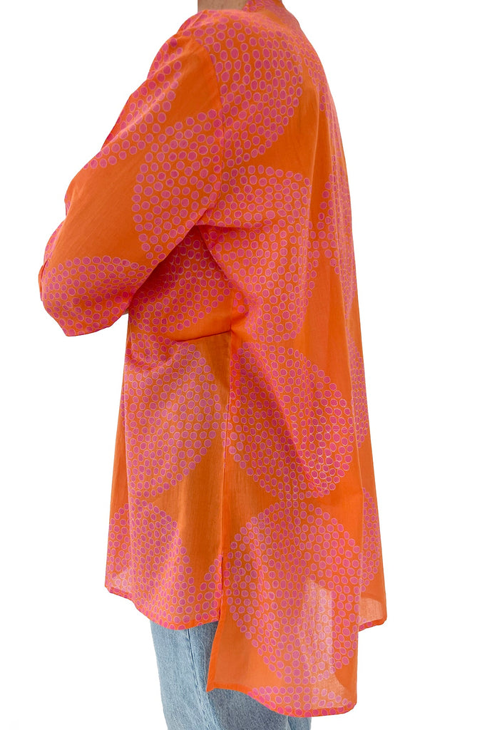 A fashionable woman wearing a pink and orange See Design Long Shirt.