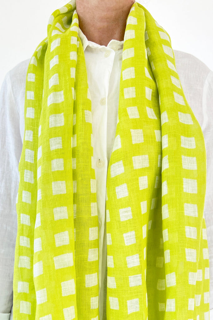 A woman wearing a colorful See Design linen scarf.
