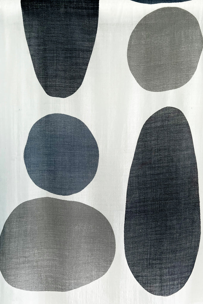A fabric with black and grey circles on it, suitable for See Design wool scarves or summer shawls.