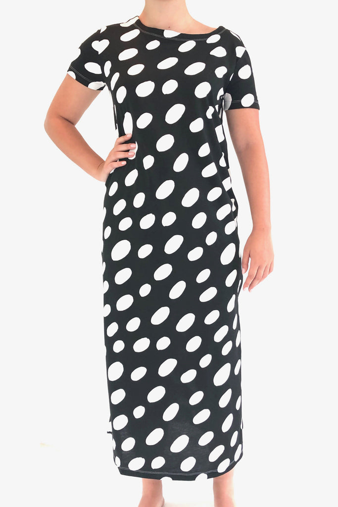 A woman wearing a comfortable black and white polka dot See Design Knit Dress Full Length.
