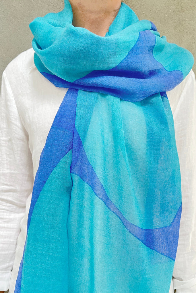 A woman wearing a bright See Design Wool Scarf.