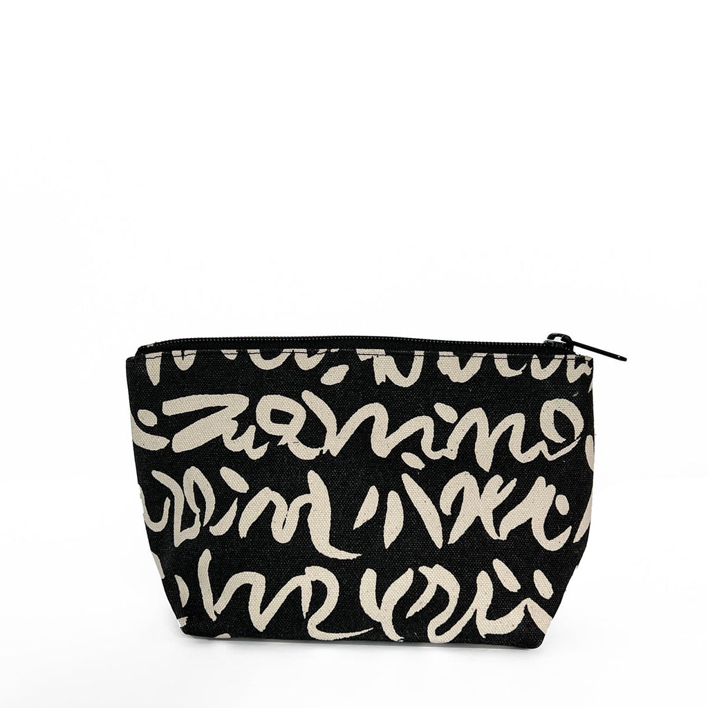 A black and white See Design small travel pouch made of 100% cotton canvas.