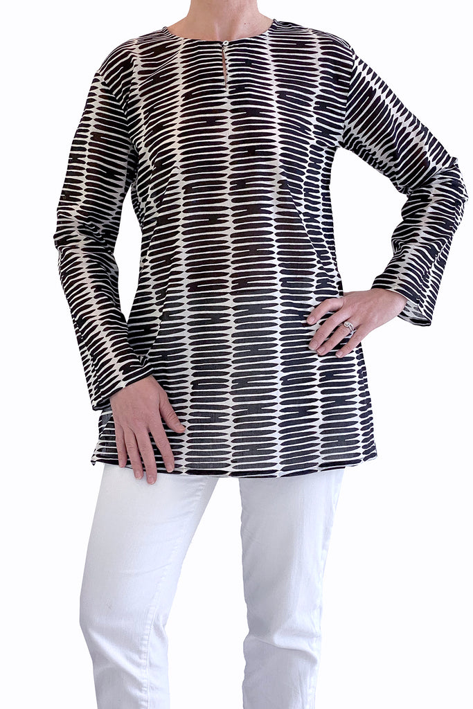 A versatile woman wearing a lightweight black and white striped See Design tunic.
