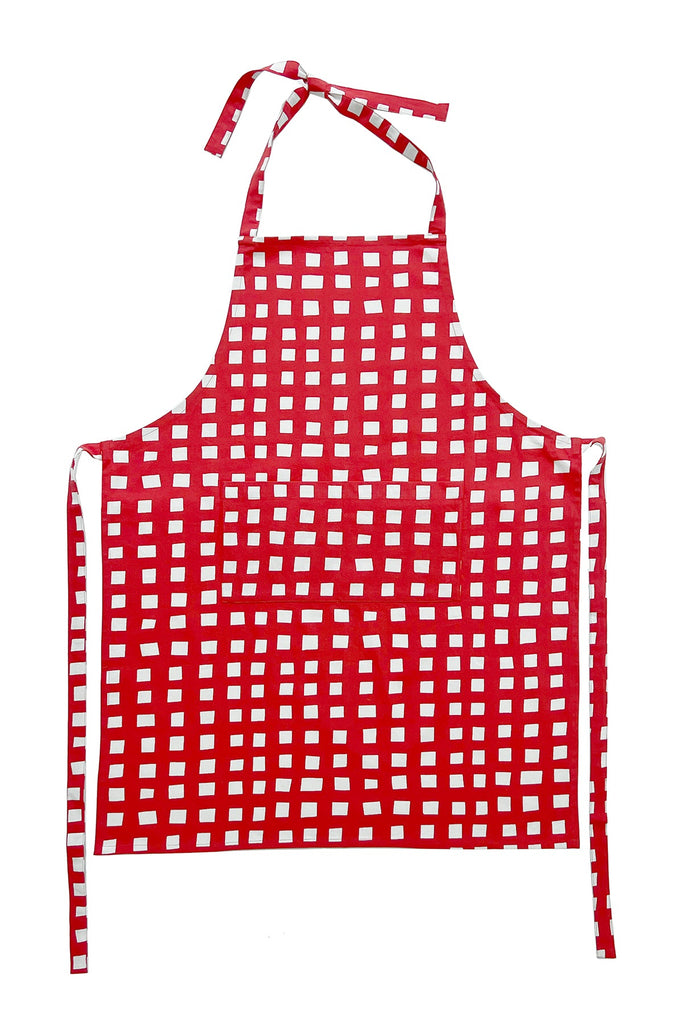 See Design's Aprons are red with a white checkered pattern, complete with neck and waist ties. Ideal for culinary adventures or as a part of a gift bundle.