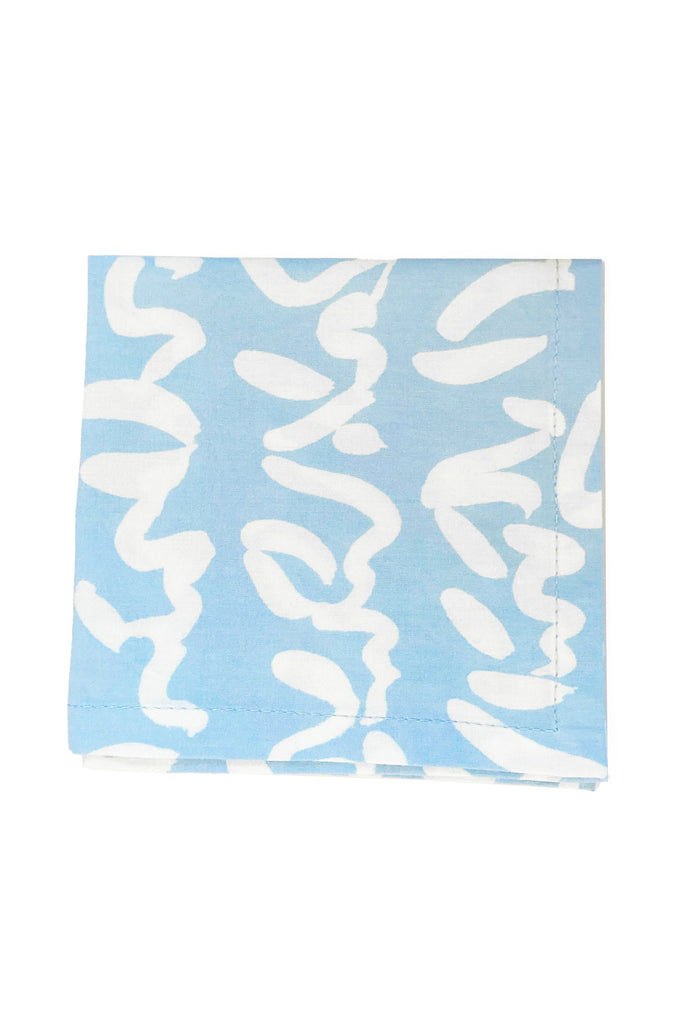 See Design's Cocktail Napkins, a set of 4 folded blue cotton pieces featuring a white abstract pattern, add an artistic touch for those who admire hand-painted designs.