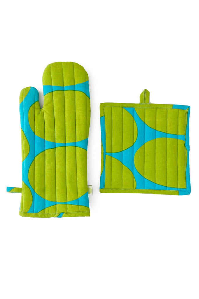 The Oven Mitt & Potholder Set by See Design features a bold circular pattern in green and blue on a white background, crafted from 100% cotton.