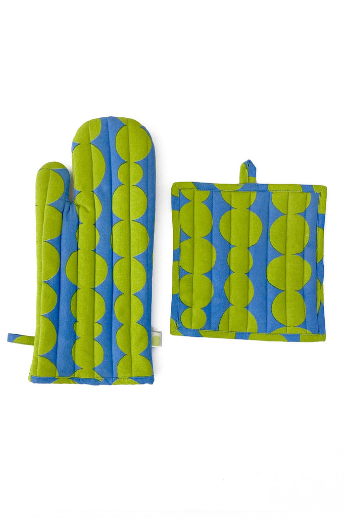 The Oven Mitt & Potholder Set by See Design is made from 100% cotton, showcasing green and blue geometric patterns on a white background.
