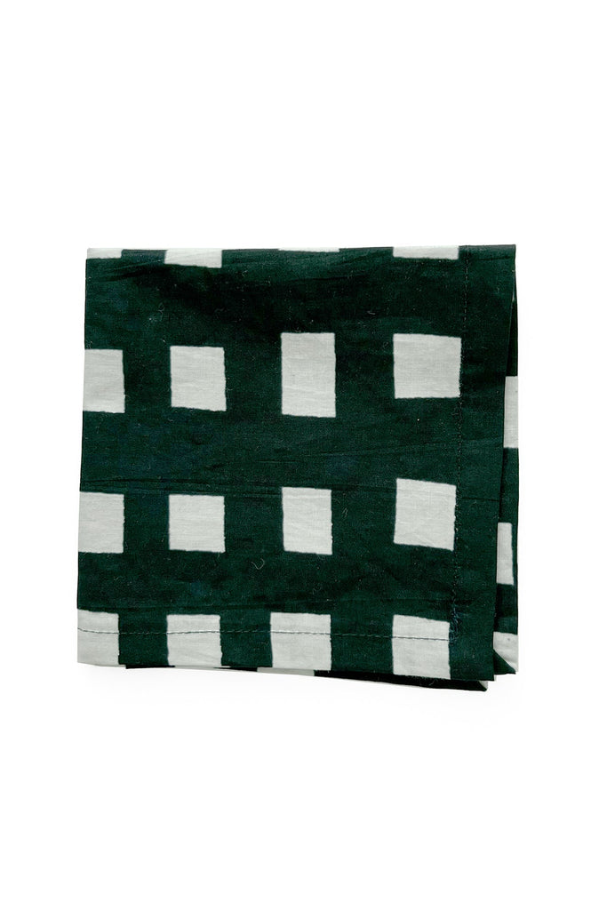 A folded piece of See Design green and white checkered cotton Cocktail Napkins (Set of 4) against a white background.