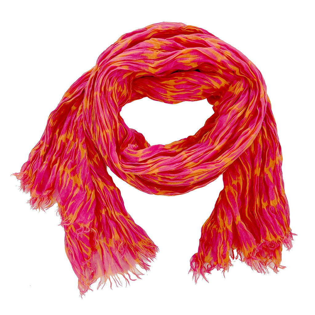 A vibrant, soft, and lightweight cotton scarf from See Design features a crinkled texture in shades of pink, red, and yellow.
