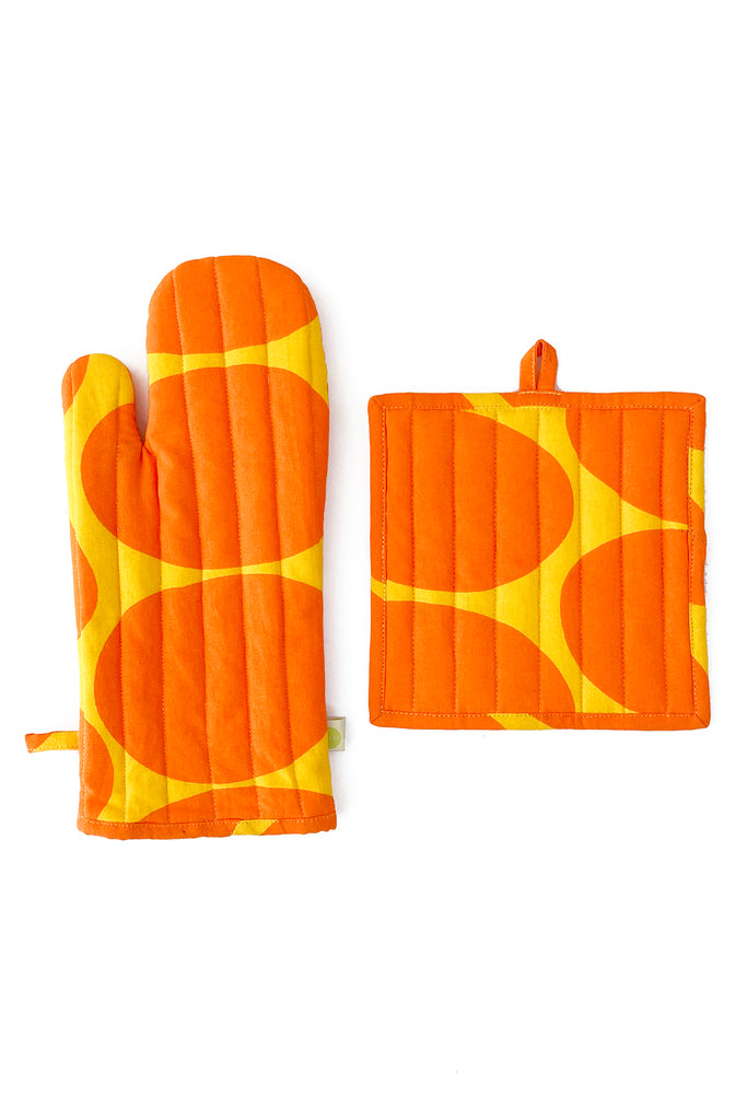 The See Design Oven Mitt & Potholder Set includes an orange quilted cotton design with yellow circular patterns on a white background.