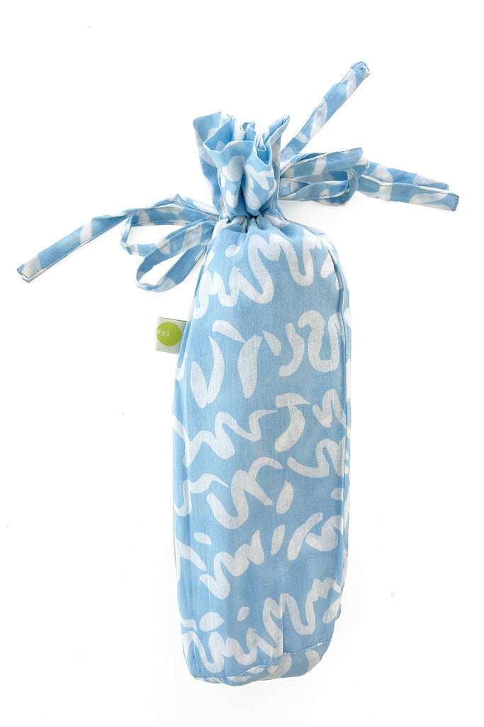 A fashionable Sarong bag made of lightweight cotton, with a ribbon tied around it. Brand Name: See Design