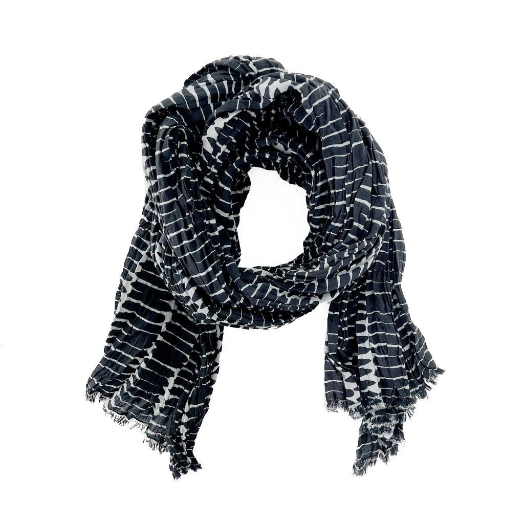 A woman wearing a See Design lightweight cotton scarf.