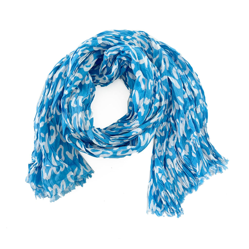 A woman wearing a See Design lightweight cotton scarf.