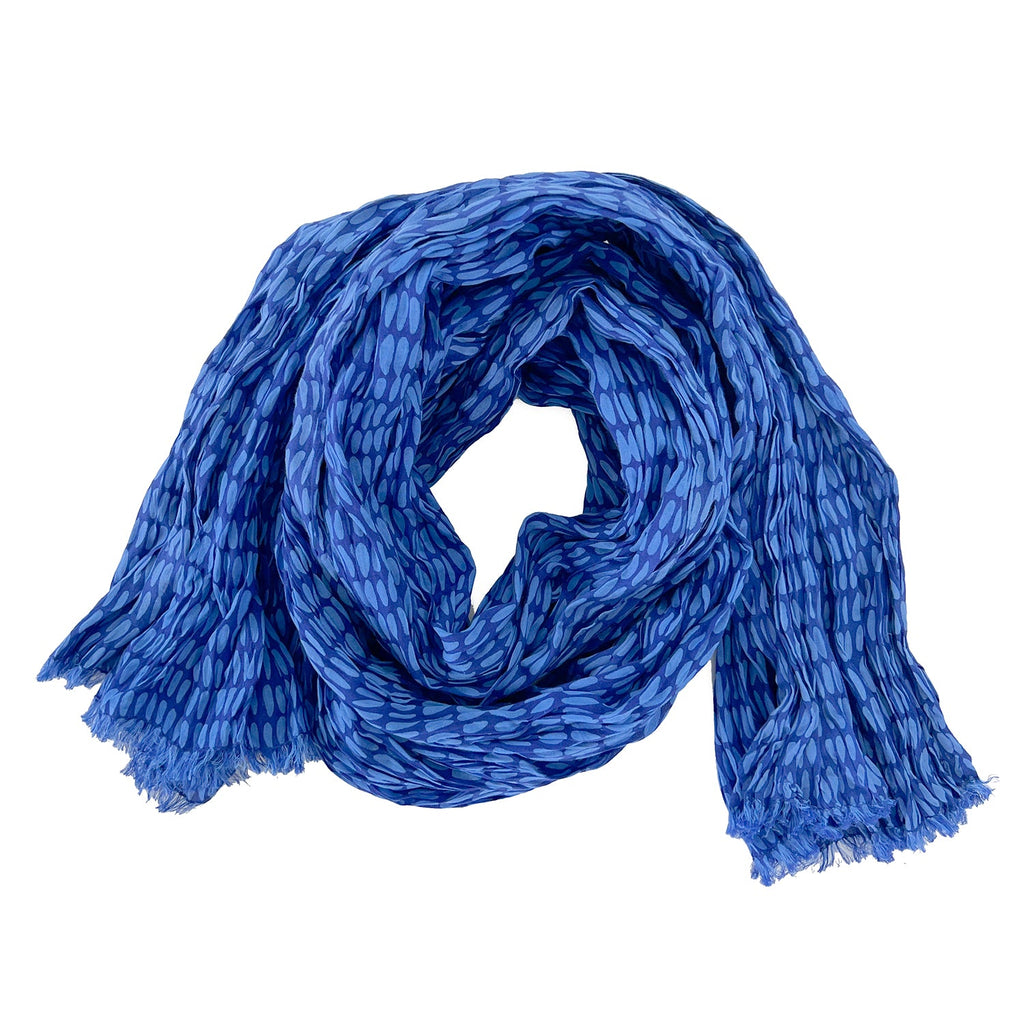 A woman wearing a See Design lightweight cotton scarf.