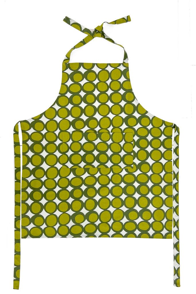 See Design Aprons: Hand-painted with a green and yellow circular pattern, neck and waist ties, plus a front pocket. Shown flat on white—an ideal gift bundle addition.