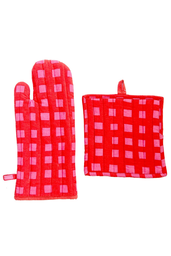 The See Design Oven Mitt & Potholder Set features a red cotton mitt and matching square potholder with pink rectangular block patterns and hanging loops, shown on a white background.
