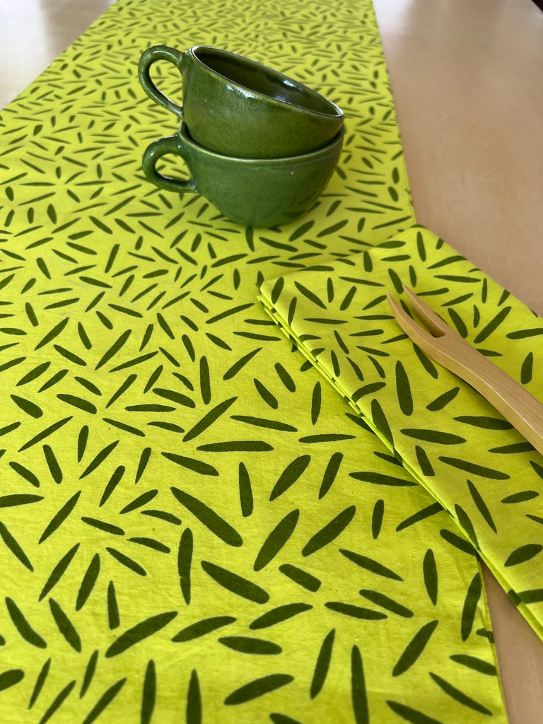 A See Design cotton table runner with green leaf prints.