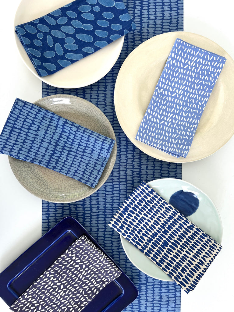 Blue and white plates and See Design cotton napkins (Set of 4) on a colorful table.
