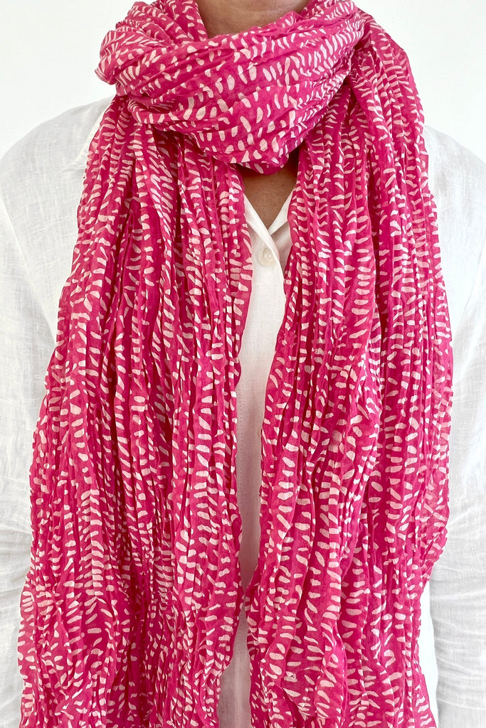 A woman wearing a See Design lightweight cotton scarf.