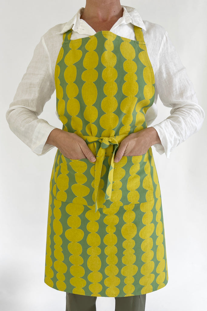 A woman wearing a vibrant kitchen apron.