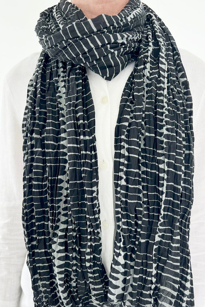 A woman wearing a See Design lightweight cotton scarf.