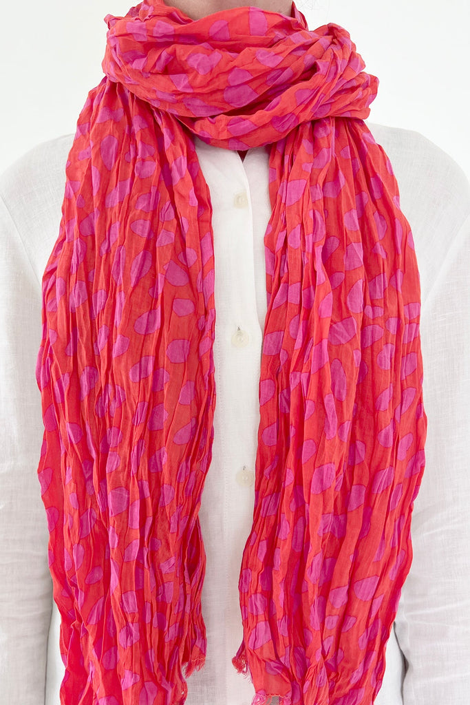 A woman wearing a See Design lightweight cotton scarf.