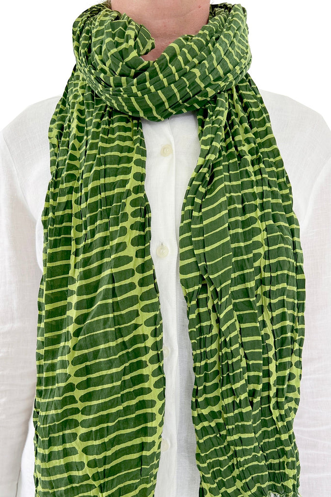 A woman wearing a See Design lightweight cotton scarf.