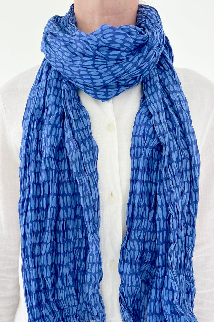 A woman wearing a See Design lightweight cotton scarf.