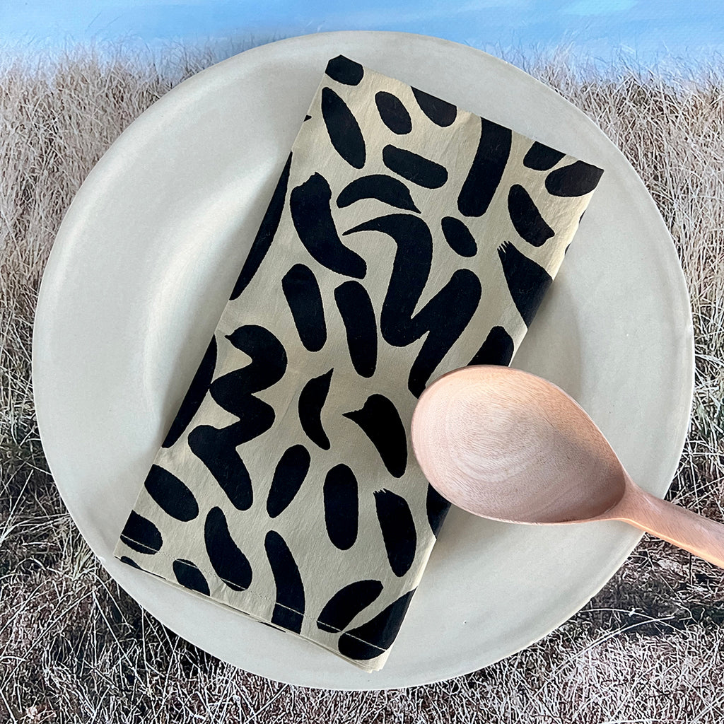 A black and white cotton Napkins (Set of 4) with a spoon on a plate, made by See Design.